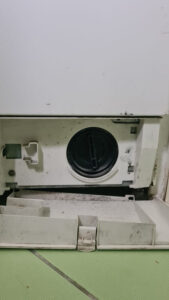 Pračka zátka filtru čerpadla. Dvířka slouží jako miska na zbytek vody